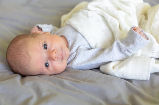 Foto vista de ângulo alto de um bebê bonito deitado na cama