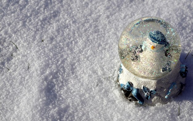 Foto vista de ângulo alto de um globo de neve em um campo coberto de neve