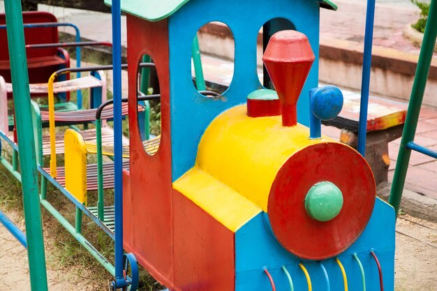 Foto vista de ângulo alto de um trem de brinquedo metálico no playground de um parque público