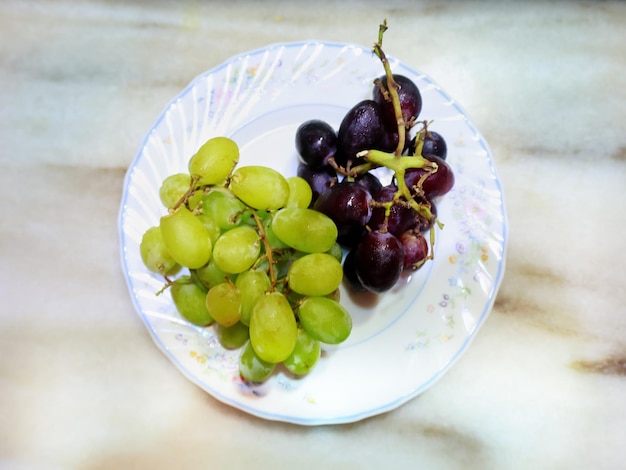 Foto vista de ângulo alto de uvas em prato sobre a mesa