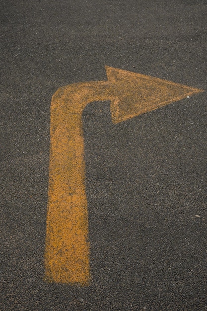 Vista de ângulo alto do símbolo de flecha na estrada