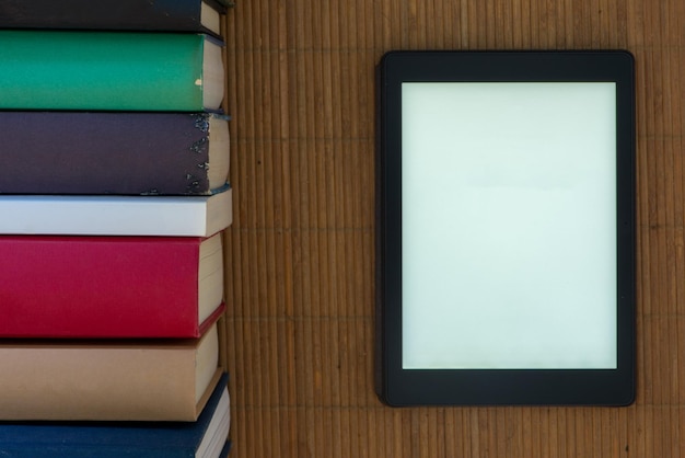 Foto vista de ângulo alto do tablet digital por livros na mesa