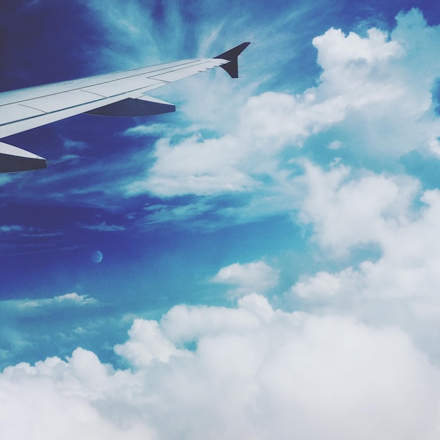 Vista de ângulo baixo da asa do avião contra o céu nublado