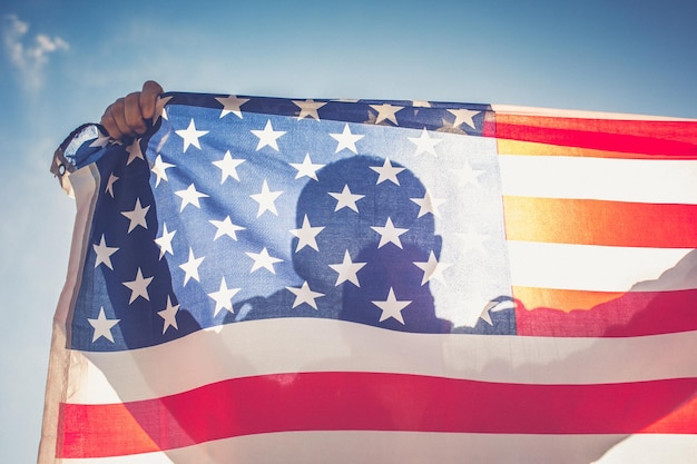Vista de ângulo baixo da bandeira americana contra o céu azul