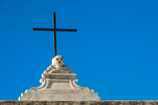 Foto vista de ângulo baixo da cruz contra o céu azul claro