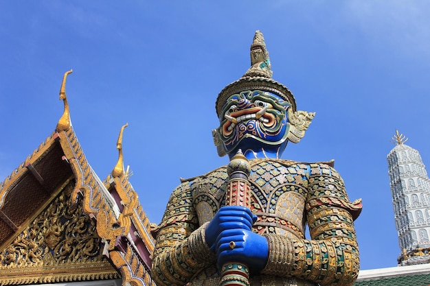 Vista de ângulo baixo da estátua do monstro e do templo contra o céu azul