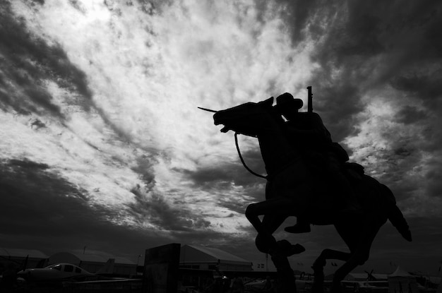 Foto vista de ângulo baixo da estátua em silhueta contra o céu nublado