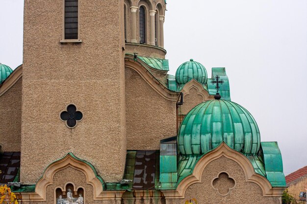 Foto vista de ângulo baixo da igreja contra telhado de metal de cúpula verde céu claro