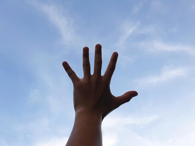 Foto vista de ângulo baixo da mão contra o céu