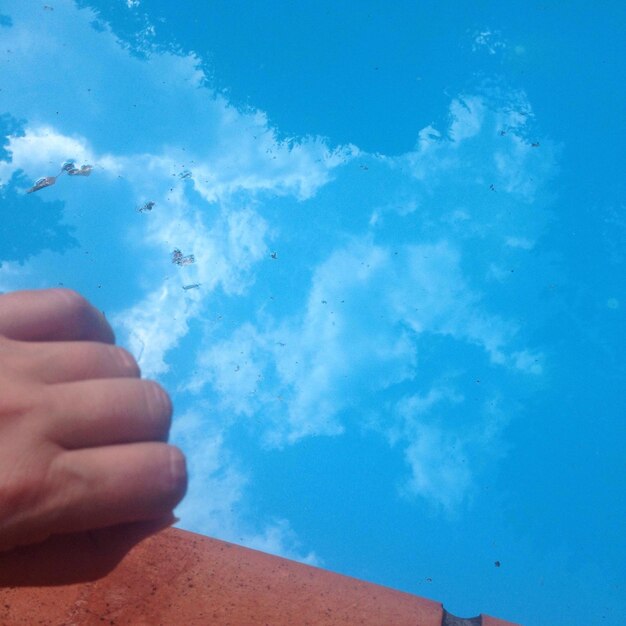 Foto vista de ângulo baixo da mão pela piscina