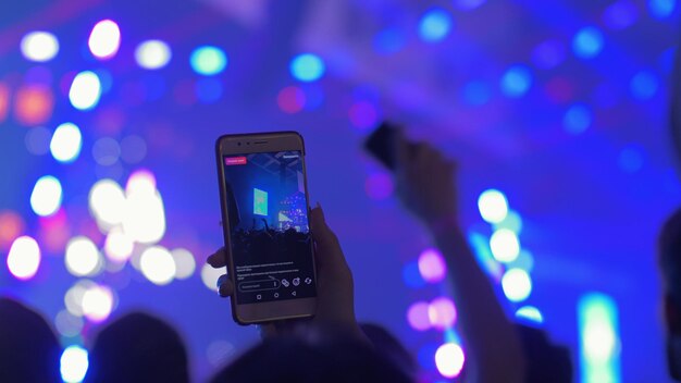 Foto vista de ângulo baixo da mão usando smartphone à noite