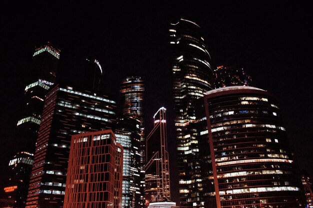 Foto vista de ângulo baixo da paisagem urbana iluminada contra o céu à noite