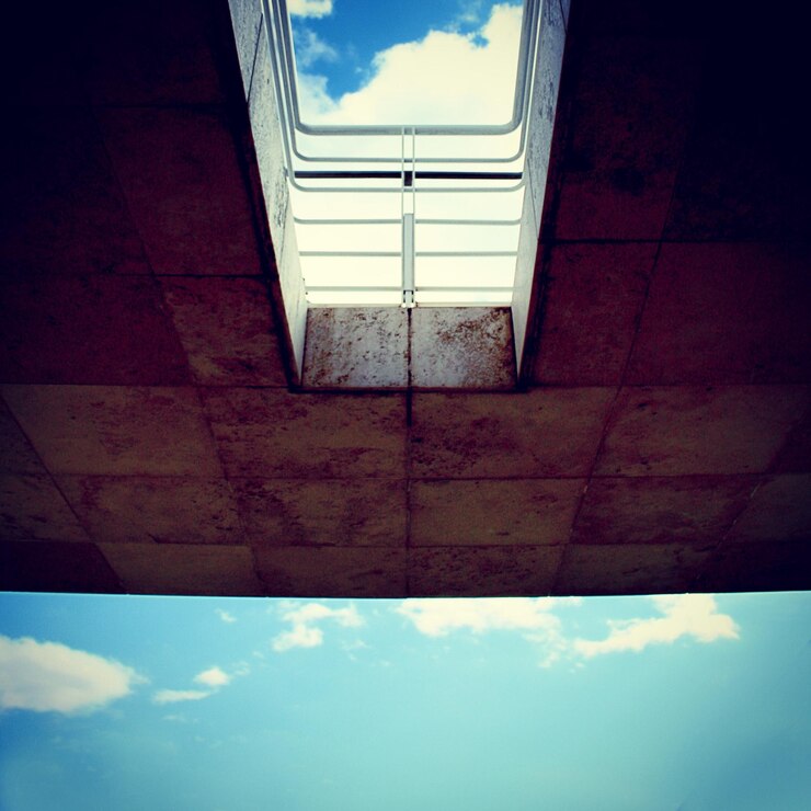 Foto vista de ângulo baixo da parede contra o céu azul e as nuvens