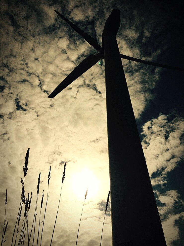 Foto vista de ângulo baixo da silhueta da turbina eólica contra o céu durante o pôr do sol