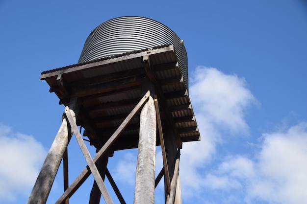 Foto vista de ângulo baixo da torre de água contra o céu nublado em um dia ensolarado