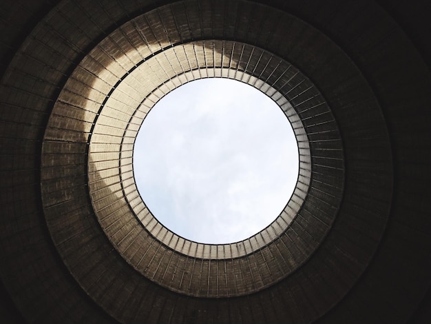 Vista de ângulo baixo da torre de refrigeração da usina nuclear contra o céu