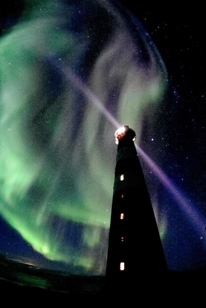 Foto vista de ângulo baixo da torre iluminada contra o céu à noite