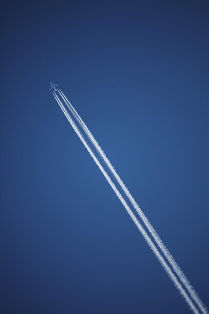 Vista de ângulo baixo da trilha de vapor contra o céu azul