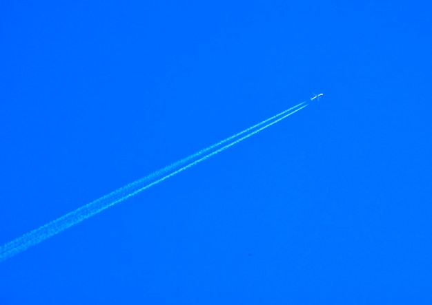 Foto vista de ângulo baixo da trilha de vapor contra um céu azul claro