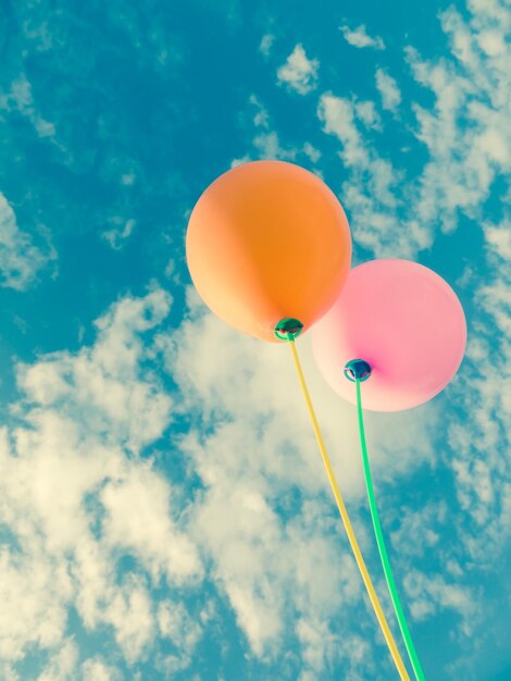 Vista de ângulo baixo de balões coloridos contra o céu azul