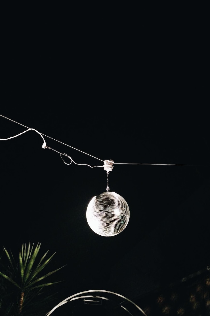 Foto vista de ângulo baixo de bola de discoteca pendurada em uma festa contra o céu à noite