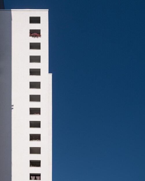 Foto vista de ângulo baixo de edifício branco contra o céu azul claro