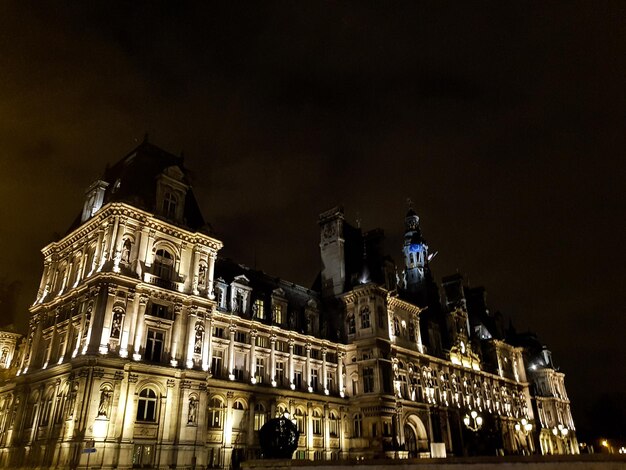 Vista de ângulo baixo de edifício iluminado contra o céu à noite