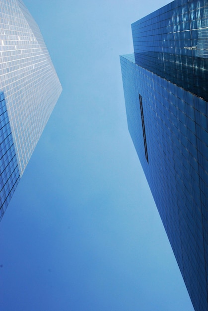 Vista de ângulo baixo de edifícios modernos contra um céu azul claro