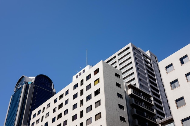 Foto vista de ângulo baixo de edifícios modernos contra um céu azul claro