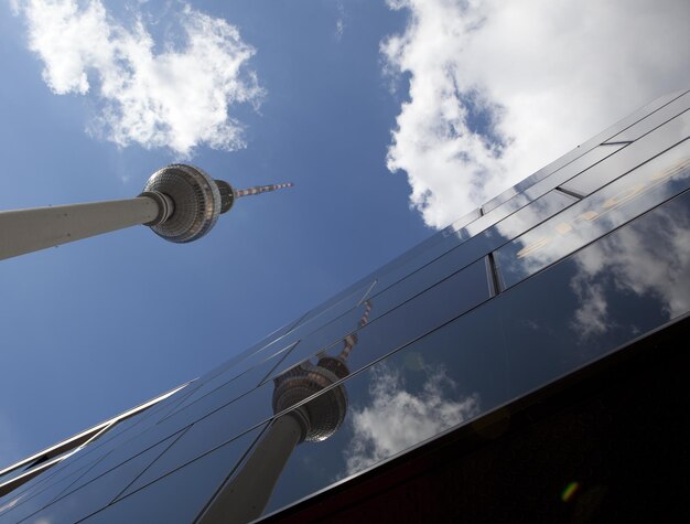 Foto vista de ângulo baixo de fernsehturm contra edifício moderno