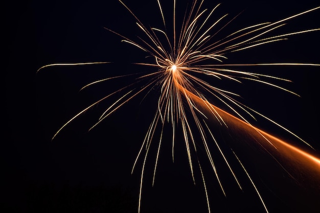 Vista de ângulo baixo de fogos de artifício explodindo contra um céu claro
