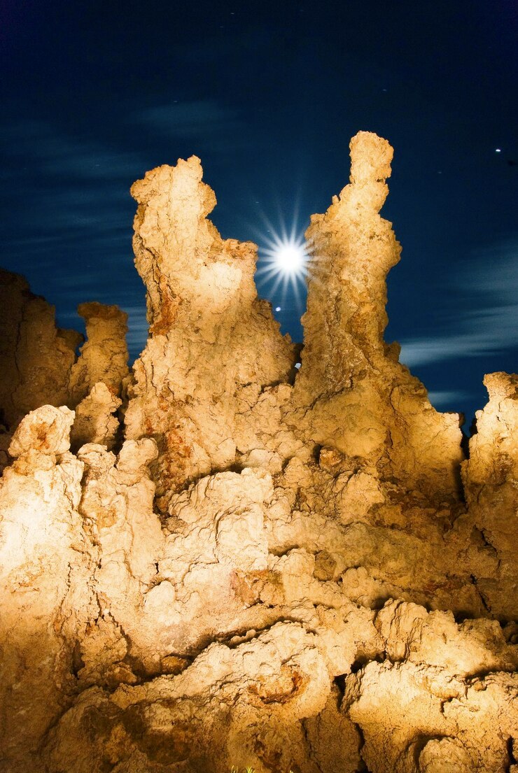 Foto vista de ângulo baixo de formação rochosa iluminada contra o céu à noite