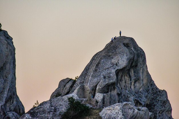 Foto vista de ângulo baixo de formações rochosas na montanha contra um céu claro