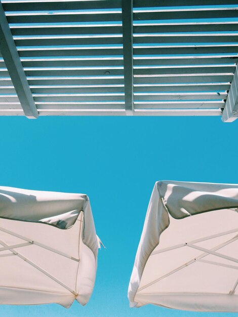 Foto vista de ângulo baixo de guarda-chuvas de praia contra um céu claro