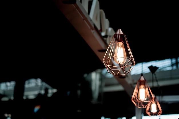 Vista de ângulo baixo de lâmpadas iluminadas penduradas em um café