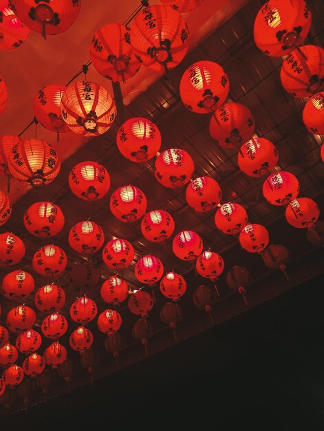 Vista de ângulo baixo de lanternas chinesas iluminadas penduradas no teto