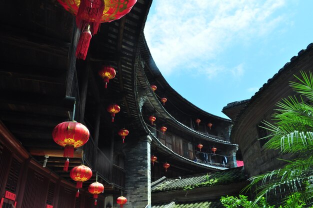 Foto vista de ângulo baixo de lanternas chinesas penduradas em edifícios contra o céu