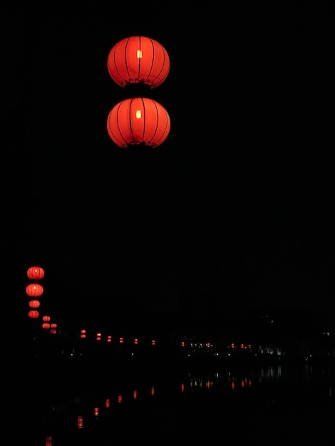 Foto vista de ângulo baixo de lanternas iluminadas contra um céu claro à noite