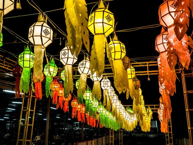 Vista de ângulo baixo de lanternas iluminadas penduradas por edifícios