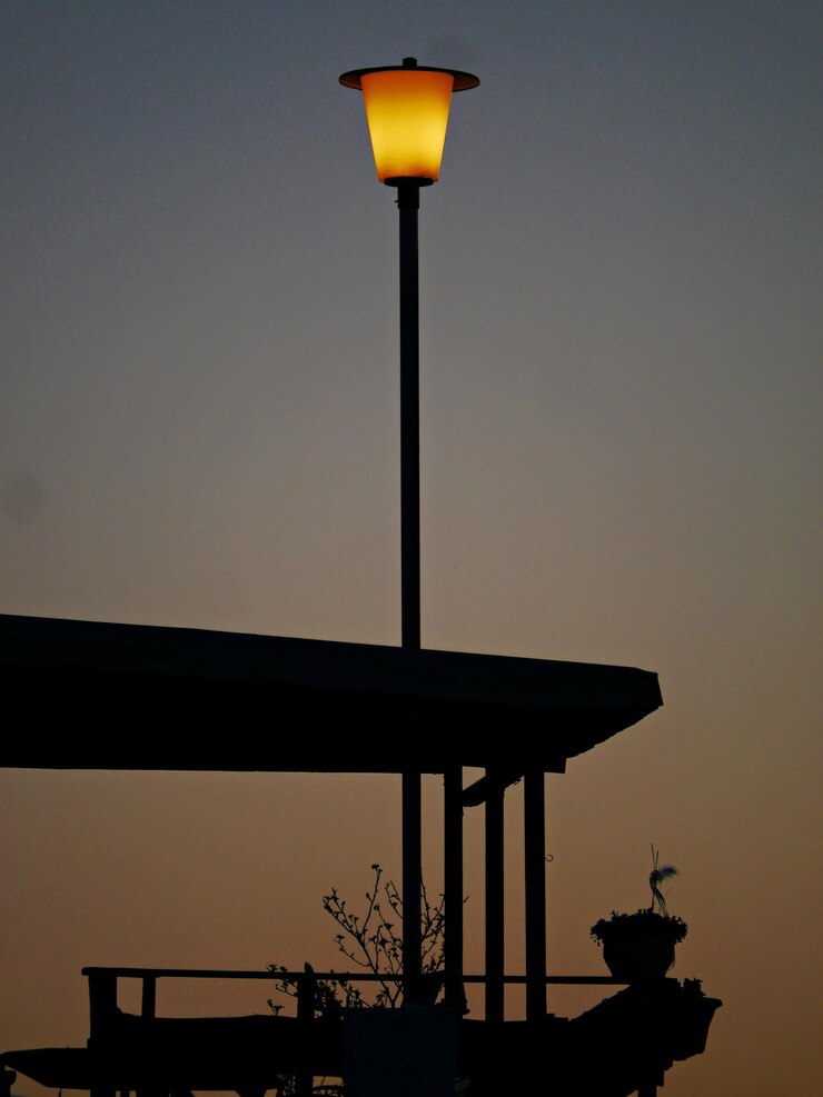 Foto vista de ângulo baixo de luz de rua iluminada contra o céu ao pôr-do-sol