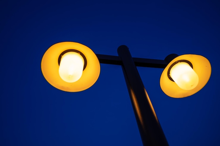 Foto vista de ângulo baixo de luz de rua iluminada contra o céu azul