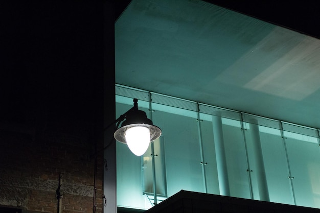 Foto vista de ângulo baixo de luz de rua iluminada contra o edifício