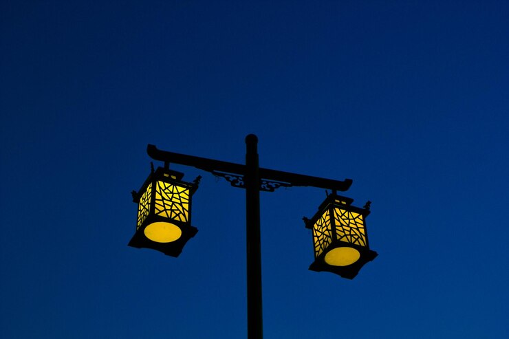 Foto vista de ângulo baixo de luz de rua iluminada contra um céu azul claro