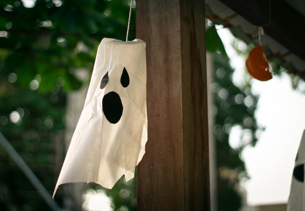 Foto vista de ângulo baixo de máscara de fantasma pendurada do telhado durante o halloween