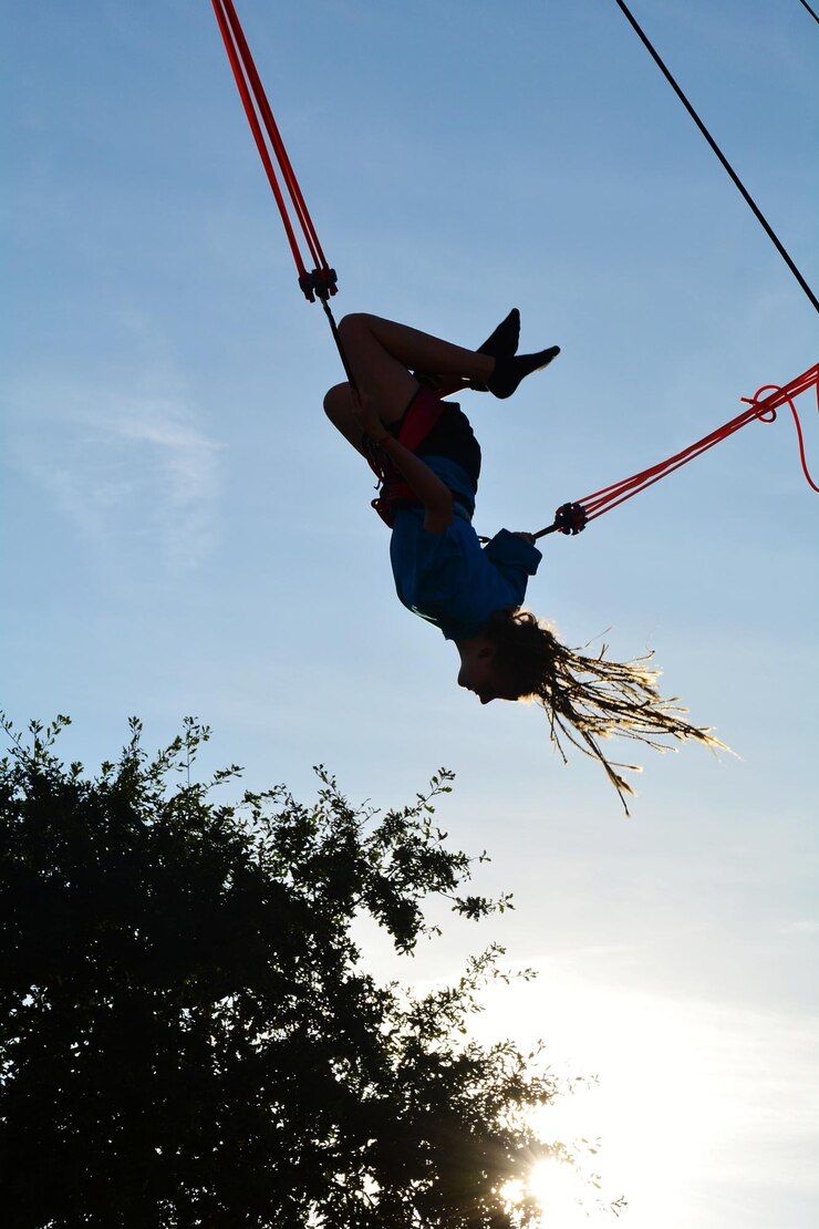 Foto vista de ângulo baixo de menina pendurada em uma corda contra o céu