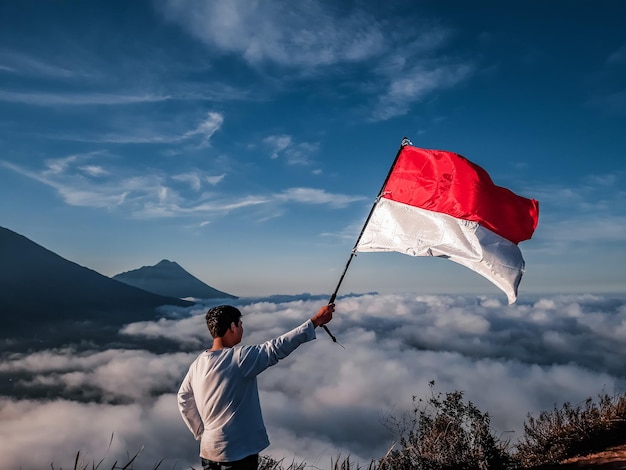 Vista de ângulo baixo de mulher segurando bandeira contra a montanha