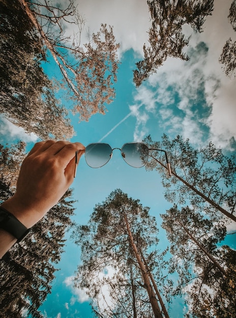 Foto vista de ângulo baixo de pessoa usando óculos de sol contra o céu