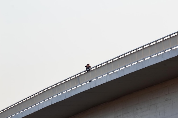 Foto vista de ângulo baixo de pessoas caminhando em uma ponte pedonal contra um céu claro