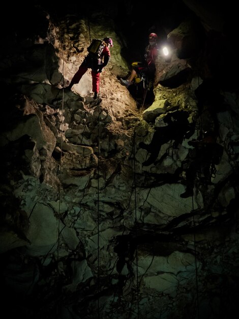 Foto vista de ângulo baixo de pessoas escalando uma rocha