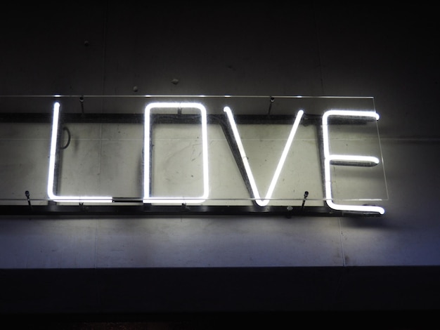 Vista de ângulo baixo de texto de amor iluminado na parede à noite